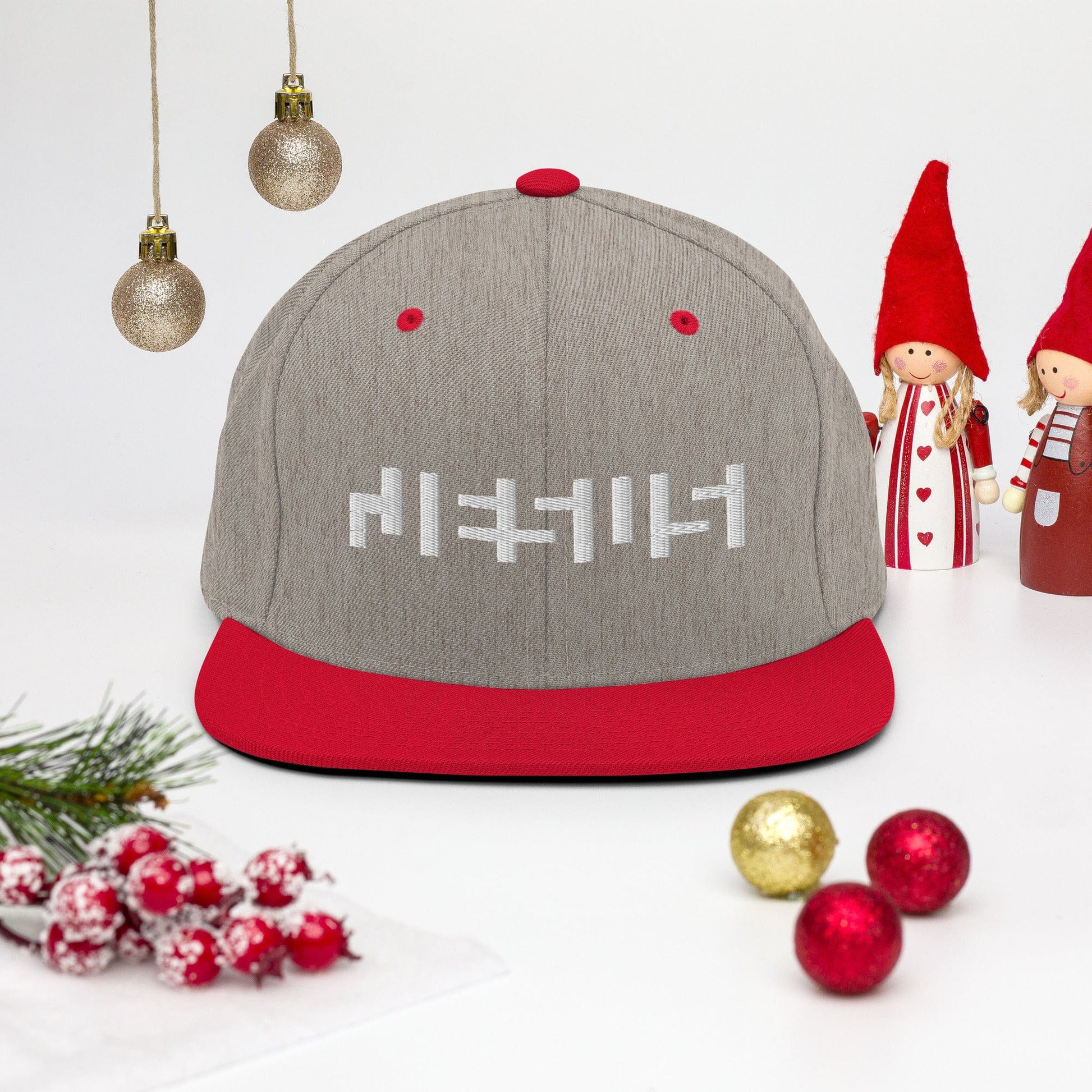 Heather Grey/ Red snapback with "Jesus" in white embroidery with background of christmas decor