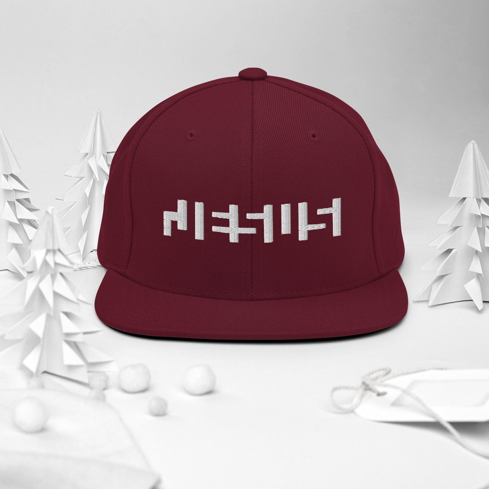 Maroon snapback with "Jesus" in white embroidery with background of christmas Decor