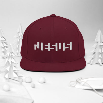 Maroon snapback with "Jesus" in white embroidery with background of christmas Decor