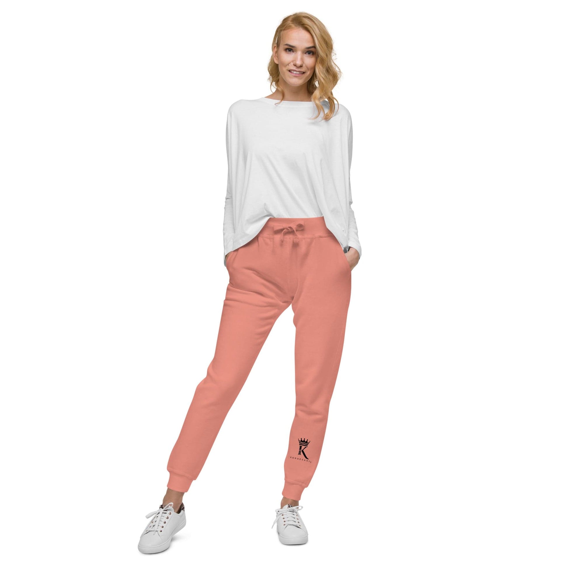 front view of woman wearing dusty rose Joggers with black Konsecrate Signature logo on left leg